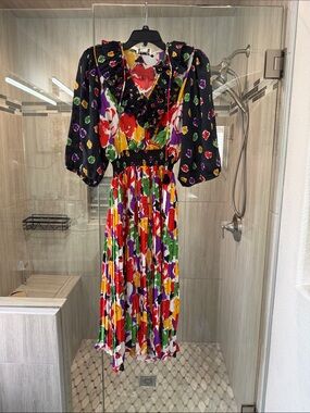 Vintage black floral dress features a pleated skirt and ruffled neckline